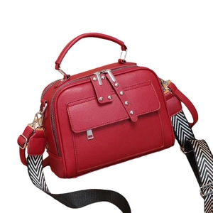 Red textured multi-layer handbag with wide woven strap and silver rivet accents