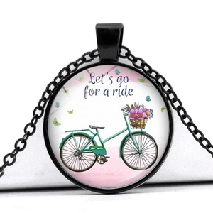 Detail shot of a vintage bicycle pendant necklace with floral basket and blue butterfly