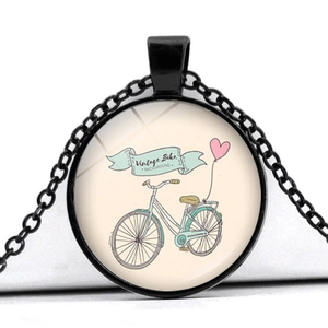 Macro shot of vintage bike pendant with heart balloons on black metal chain