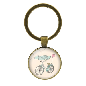 Macro view of vintage bronze bicycle keychain with illustration in glass dome pendant