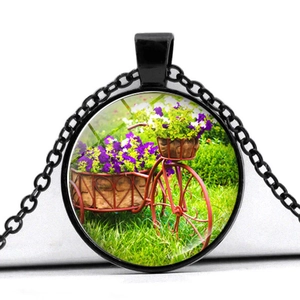 Vintage black bicycle pendant necklace featuring a flower basket design with glass cover