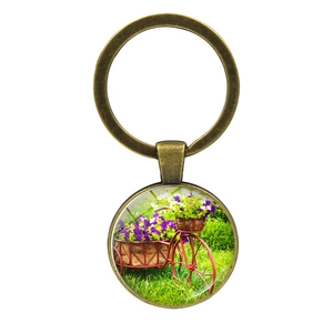 Vintage bronze bicycle keychain with floral basket pendant in a rustic garden style