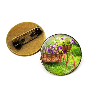 Broche vélo vintage avec panier de fleurs en verre bombé et base en bronze vieilli