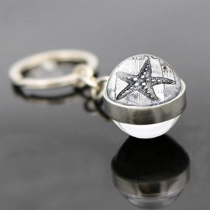 Macro shot of glass ball keychain with starfish design and BEACH text detail