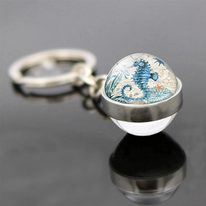 Macro detail of nautical sea horse illustration inside a glass sphere keychain pendant