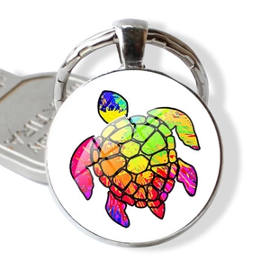 Gros plan sur porte-clés tortue colorée avec dôme en verre et détail de clé en métal argent
