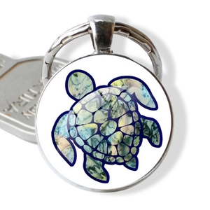 Détail du porte-clés tortue colorée sous dôme de verre avec anneau en métal argenté