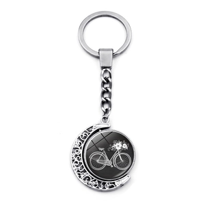 Detail of vintage bicycle keychain with silver crescent moon hollow pattern and floral pendant
