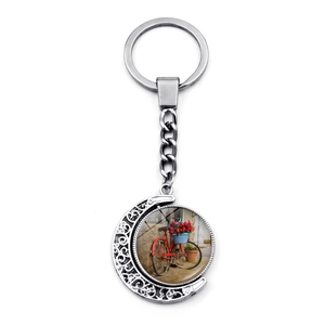 Detail of vintage bicycle flower basket keychain with rotating crescent moon pendant