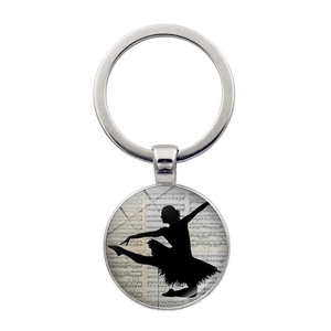 Dettaglio portachiavi con silhouette di ballerina e spartito musicale su vetro