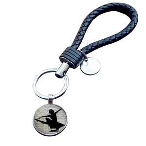 Portachiavi ballerina elegante con spartito musicale e cordino in pelle nera intrecciata