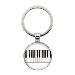 Macro detail of silver musical keychain with heart piano keys pattern inside glass