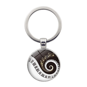 Detailed view of silver music keychain with black and white piano spiral and golden notes