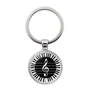 Macro detail of silver musical keychain with treble clef and piano keys graphic charm