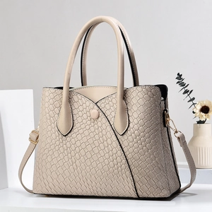 Close-up of stone pattern embossed texture and V-shaped stitching on beige tote bag