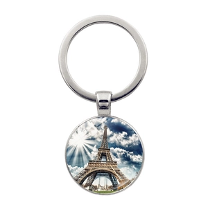 Detailed view of silver Eiffel Tower keychain pendant with glass dome art and blue sky