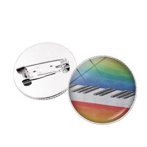 Détails recto et verso d'une broche ronde motif touches de piano arc-en-ciel