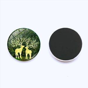 Christmas reindeer glass fridge magnet set with gold elk silhouettes on green forest background
