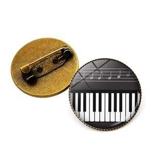 Dettaglio della base in bronzo vintage e della chiusura di sicurezza di questa spilla piano