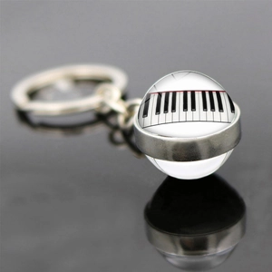 Detailed macro view of a crystal ball keychain with a piano keyboard pattern and silver ring
