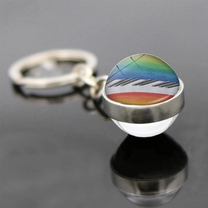 Macro detail of glass dome keychain showing piano keys with rainbow gradient artwork
