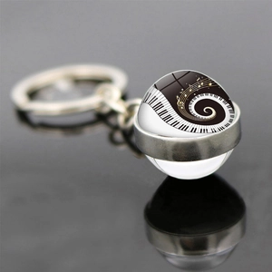 Macro view of double-sided glass pendant with piano keys and musical notes design