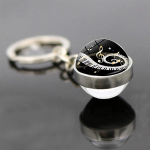Musical piano keyboard heart keychain with treble clef and note in double-sided glass ball