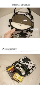 Detail view of cow print mini backpack showing interior structure and storage capacity