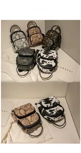 Detail view of mini backpacks in cow print and faux snake patterns with gold logos