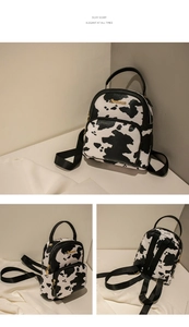Detail view of mini cow print backpack with gold hardware and black textile straps
