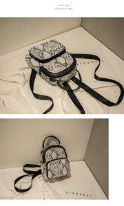 Detail of mini backpack with black and white snake print faux leather and golden zipper