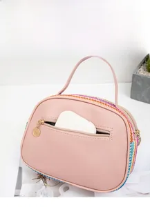 Dettaglio borsa di paglia rosa con trama arcobaleno, tasca posteriore e zip dorata