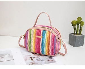 Dettaglio borsa a tracolla arcobaleno in paglia con manico in pelle rosa e oro