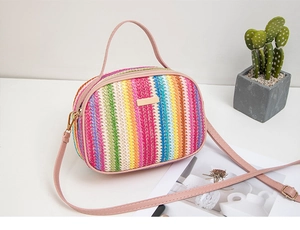 Dettaglio borsa di paglia intrecciata arcobaleno con manico rosa e chiusura dorata