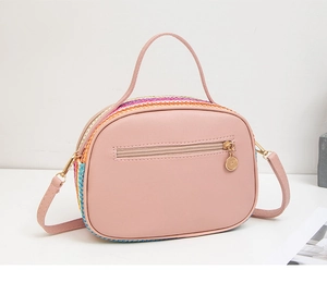 Dettaglio della borsa a tracolla intrecciata colorata con finiture rosa e oro
