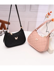 Detail of pink and black quilted butterfly crescent underarm bags on a white table