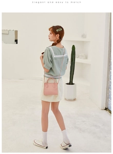 Detail of light pink crocodile pattern handbag worn with an elegant lace outfit
