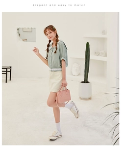 Detail of elegant pastel outfit featuring light green sailor collar shirt and yellow skirt