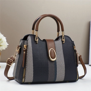 Kontrastfarbene Beuteltasche mit braunem Lederbesatz und goldenen Metalldetails