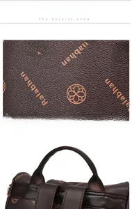 Macro detail of waterproof brown oxford fabric with orange logo print and top handle strap