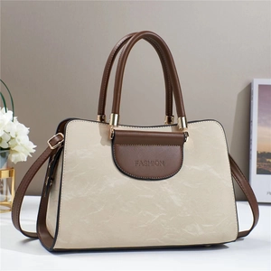 Detail of cream and brown crossbody bag with FASHION embossed logo and handle strap