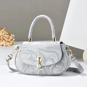 Detailed macro view of grey marble pattern PU handbag with golden star pendant charm