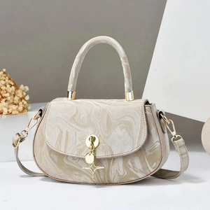 Detail of marble pattern crossbody bag with gold hardware and star pendant