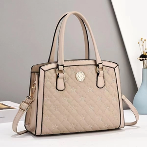 Elegante apricotfarbene Stepptasche mit Sternnähten und goldener Hardware in Szene