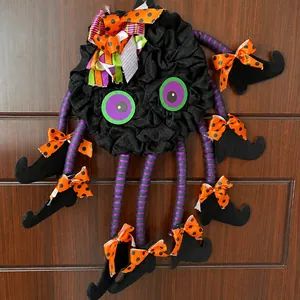 Λεπτομέρεια από στεφάνι Halloween με ριγέ πόδια αράχνης και μπότες μάγισσας σε ξύλινη πόρτα