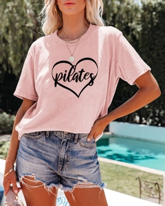 Close-up of pink Pilates heart T-shirt showing fabric texture and printed artwork