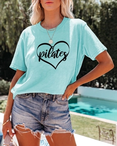 Close-up of light blue Pilates cotton t-shirt with heart graphic and cursive text