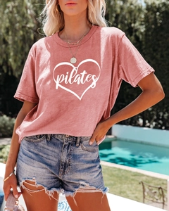 Close-up of pink Pilates t-shirt featuring a white hand-drawn heart outline design