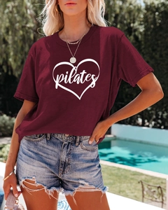 Detail of burgundy Pilates t-shirt featuring a white heart print and loose cotton fit
