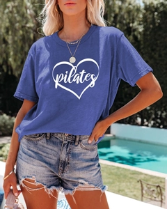 Close-up of blue Pilates heart t-shirt worn with denim shorts by an outdoor pool